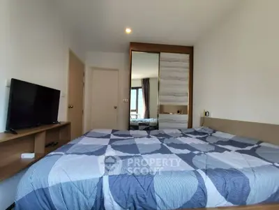Modern bedroom with large bed and mirrored wardrobe in stylish apartment.