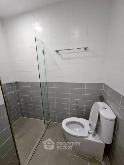Modern bathroom with sleek design featuring a glass shower and tiled walls.