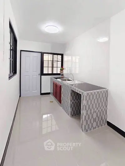 Modern minimalist kitchen with sleek tile design and ample natural light.