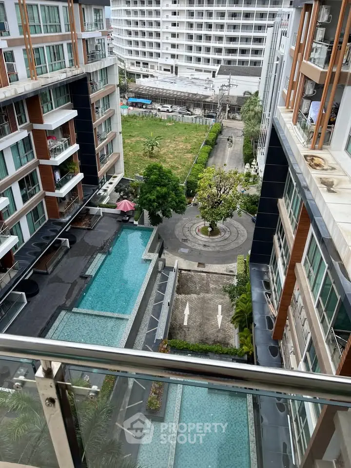 Modern condominium with pool view and spacious balcony overlooking urban landscape.