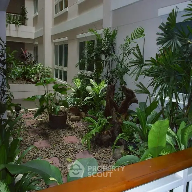 Lush indoor garden in modern building atrium with tropical plants and natural light.