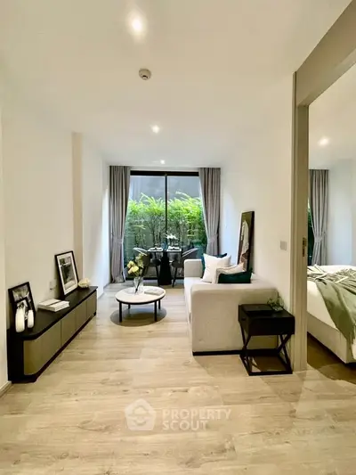 Modern living room with elegant decor and large windows overlooking lush greenery.