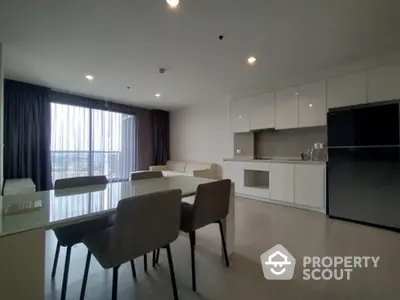 Modern open-layout kitchen and living area with sleek design and natural light.