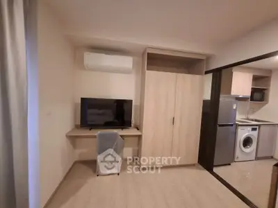 Modern apartment interior with TV, desk, and kitchen appliances