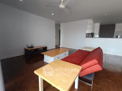 Spacious living room with modern furniture and open kitchen layout.