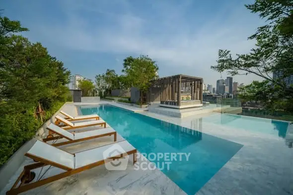 Luxurious rooftop pool with city skyline view and modern lounge chairs.