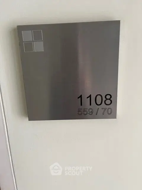 Modern apartment number plaque on wall, sleek design.