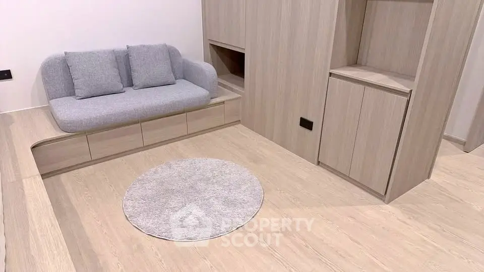 Modern minimalist living room with light wood flooring and built-in storage