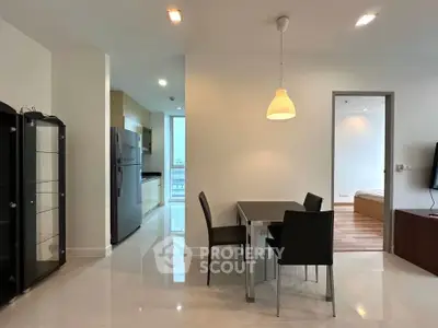 Modern open-plan living and dining area with sleek furniture and bright lighting.