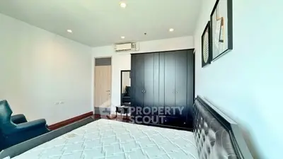 Spacious bedroom with modern furniture and ample natural light.