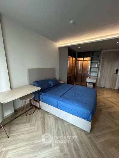 Modern bedroom with stylish herringbone flooring and sleek design