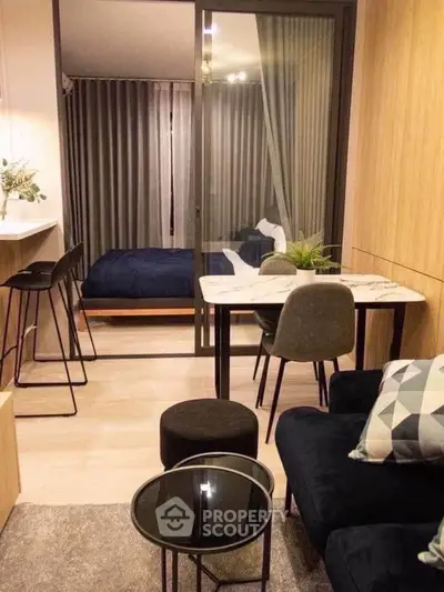 Modern studio apartment with stylish decor and open layout, featuring a cozy living area and elegant bedroom.