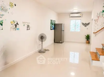 Spacious minimalist room with glossy floors, wall art, and modern appliances.