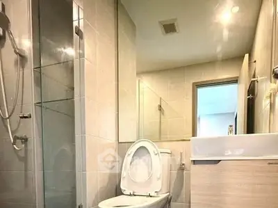 Modern bathroom with glass shower and sleek fixtures in a contemporary apartment.