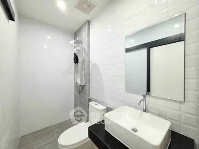 Modern minimalist bathroom with sleek fixtures and white tile design.