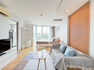 Modern open-plan living room and bedroom with stylish decor and natural light.