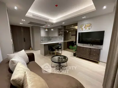 Modern living room with open kitchen, stylish decor, and cozy seating area.