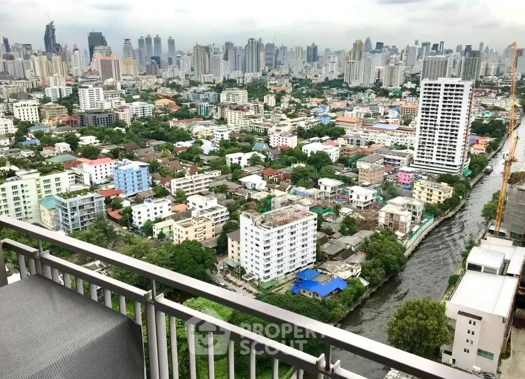 Stunning cityscape view from a high-rise balcony overlooking urban skyline and river.