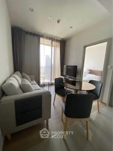 Modern living room with cozy seating and natural light in a stylish apartment.