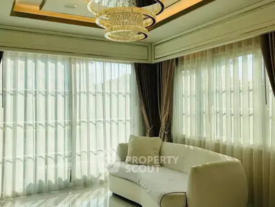 Luxurious living room with elegant chandelier and large windows