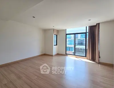 Spacious empty living room with large windows and wooden flooring