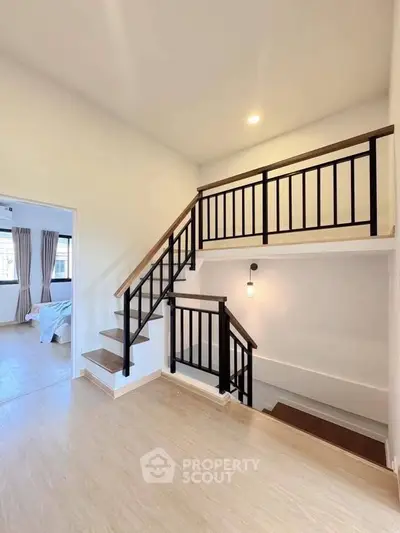Modern duplex interior with stylish staircase and bright natural lighting.