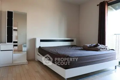 Spacious modern bedroom with stylish furniture and natural light from large window.