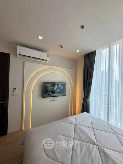 Modern bedroom with stylish lighting, wall-mounted TV, and city view through large window.