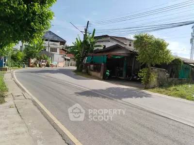 Charming suburban street view with lush greenery and traditional houses, perfect for tranquil living.