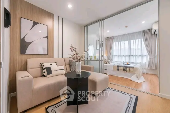 Modern living room with stylish decor and cozy bedroom view in open layout apartment.