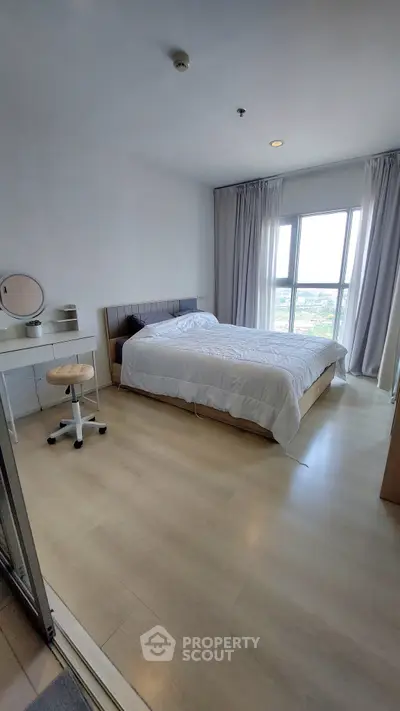 Spacious bedroom with large window offering stunning views, featuring modern furniture and elegant decor.
