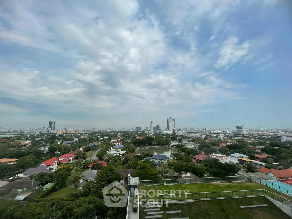 Stunning cityscape view from a high-rise building showcasing urban skyline and lush greenery.