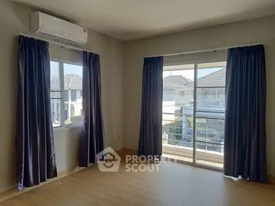 Bright room with large windows and air conditioning, offering a view of neighboring houses.