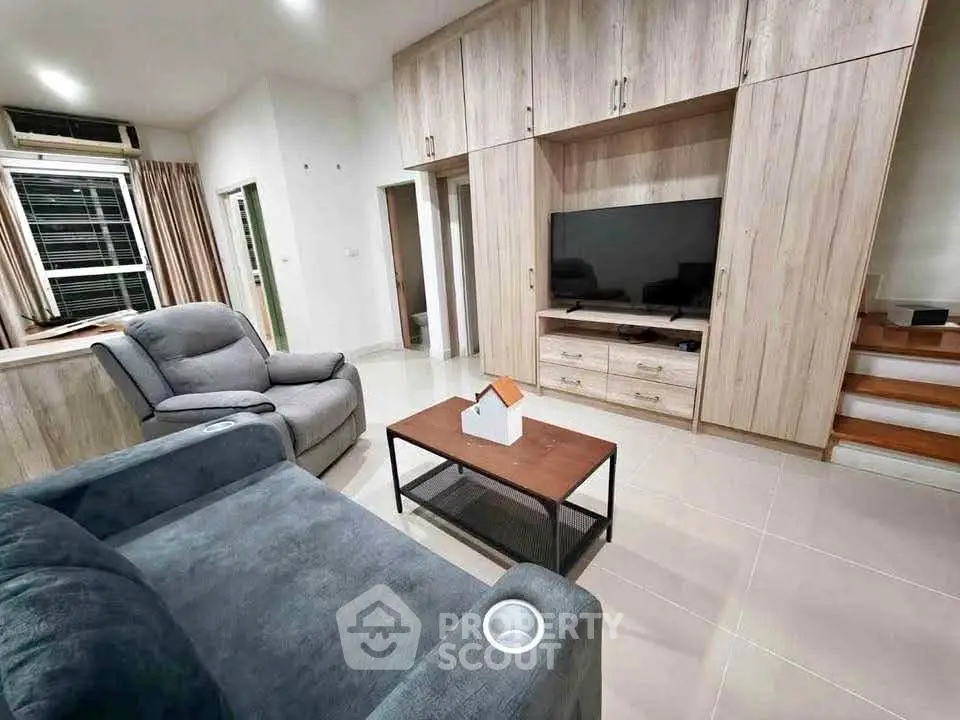 Spacious living room with modern furniture and built-in entertainment center.