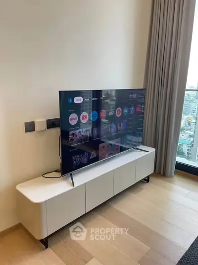 Modern living room with sleek TV setup and city view, perfect for urban living.