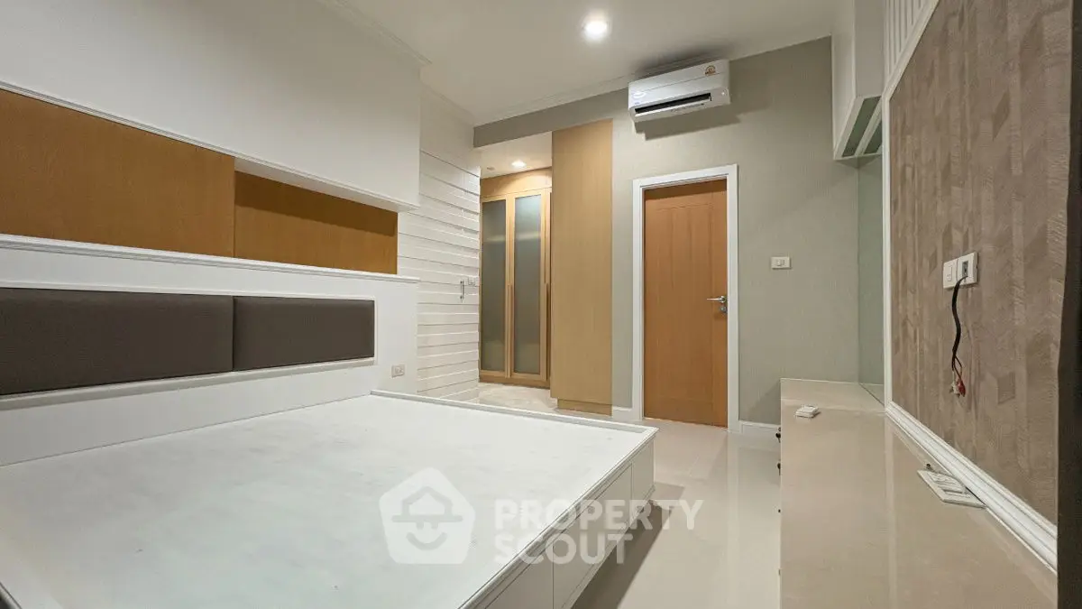 Modern bedroom with built-in wardrobe and air conditioning unit