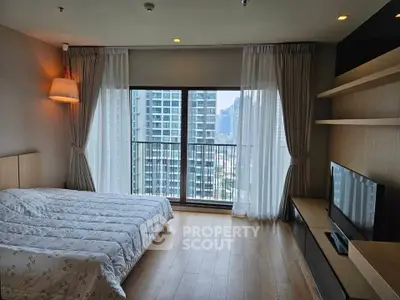 Modern bedroom with large window and city view, featuring stylish decor and natural light.