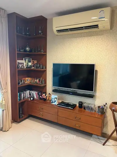 Charming living room with built-in wooden shelves and modern air conditioning unit.