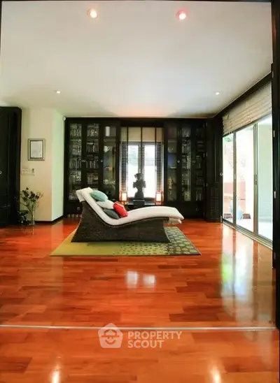 Spacious living room with elegant wooden flooring and modern lounge chair.