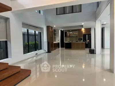 Spacious modern living room with open kitchen and large windows in luxury home