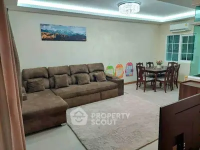 Spacious living room with plush sofa and elegant dining area in modern apartment.