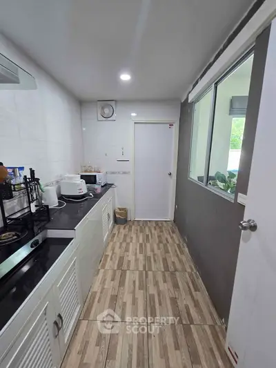 Modern kitchen with sleek appliances and stylish wooden flooring