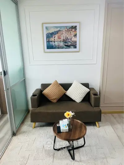 Cozy living room with modern sofa, stylish decor, and elegant wall art, perfect for relaxation.