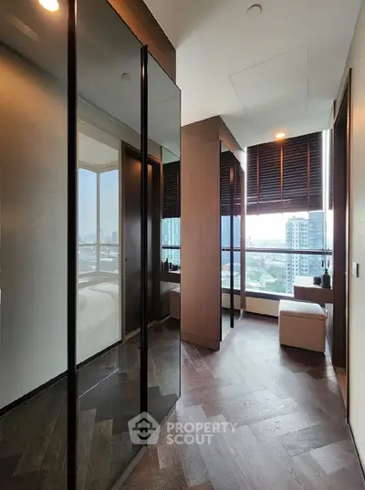 Luxurious modern bedroom with floor-to-ceiling windows and stunning city view, featuring elegant wood flooring and stylish decor.