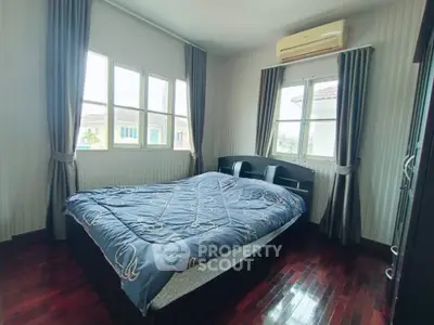 Cozy bedroom with large windows and air conditioning in modern home