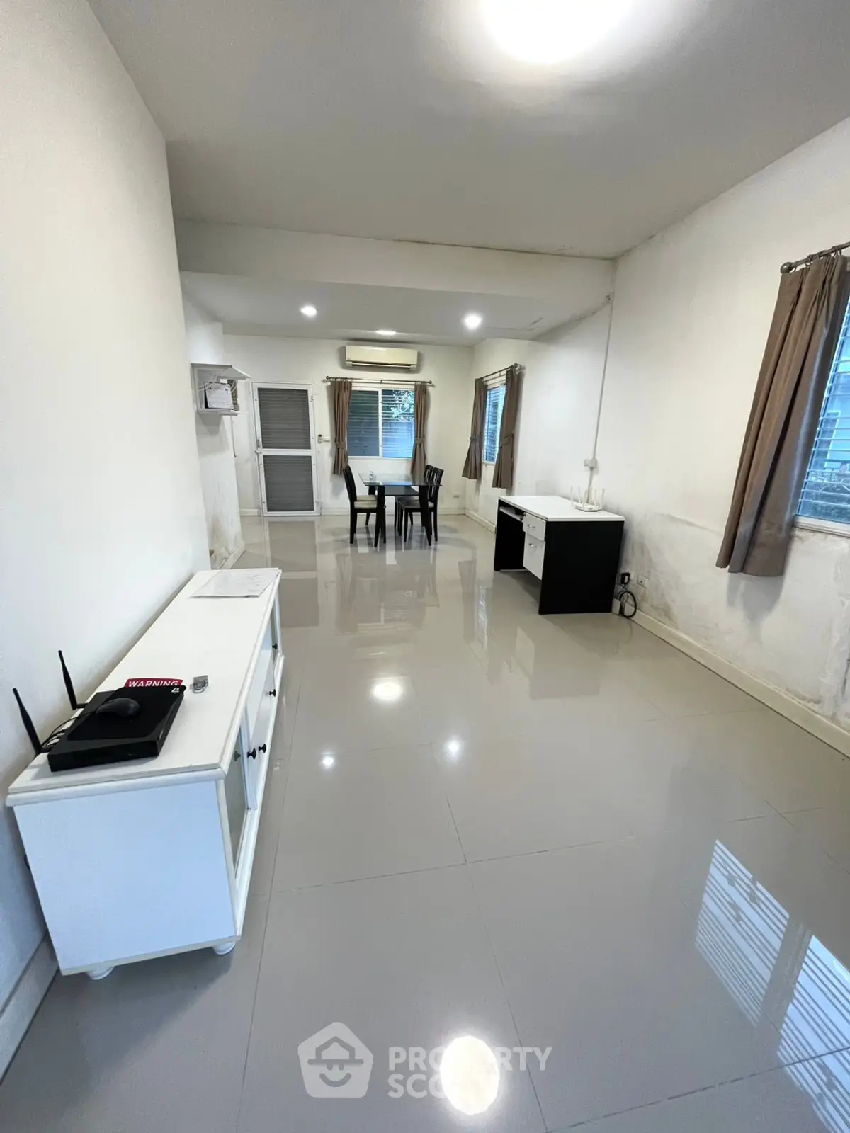Spacious living room with modern furniture and natural light, perfect for relaxation and entertainment.