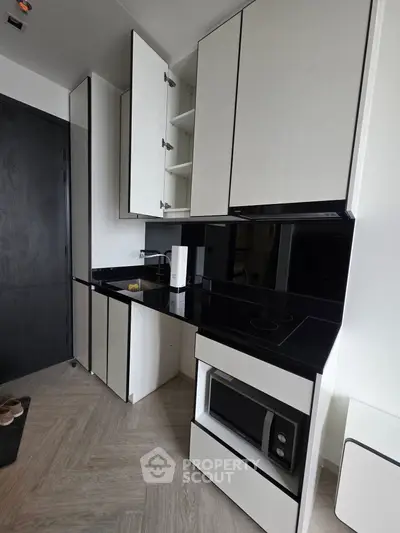 Modern kitchen with sleek black and white cabinetry and built-in appliances