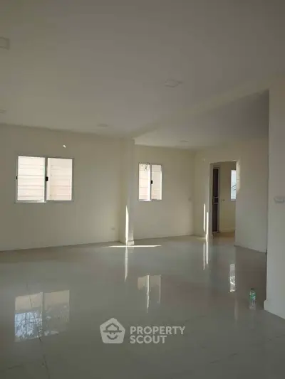 Spacious empty room with large windows and tiled floor, perfect for customization.
