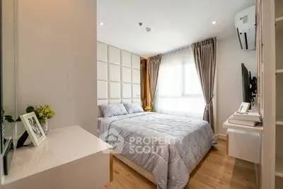 Modern bedroom with stylish decor and natural light, featuring a cozy bed and elegant furnishings.