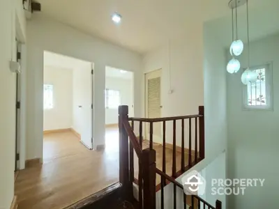 Bright and spacious hallway with wooden flooring and modern lighting